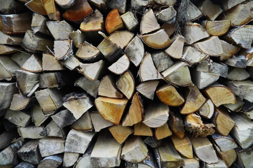 Grumes de bois de chauffage empilées avant leur débit et leur séchage.