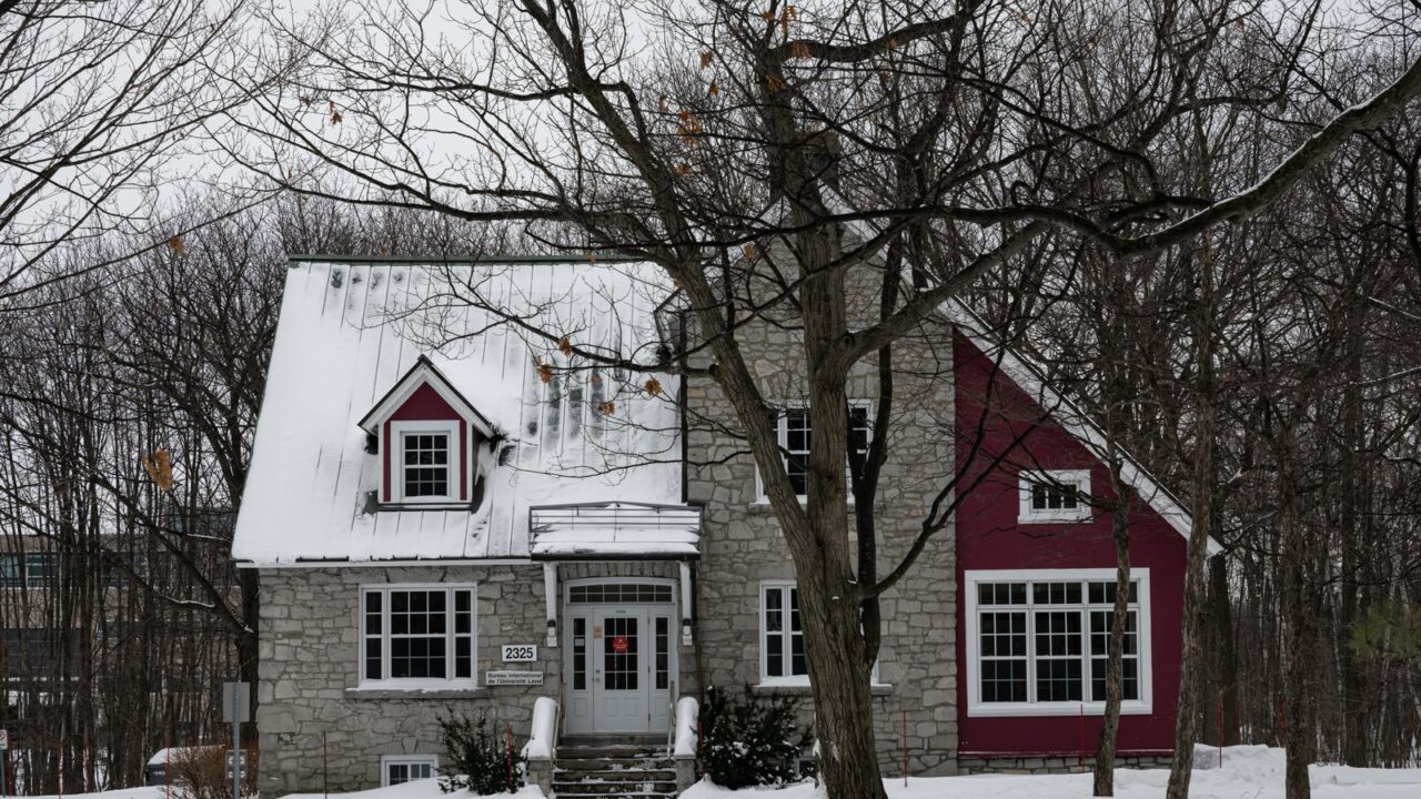 Maison en pierre et bardage rouge sous la neige près de Québec